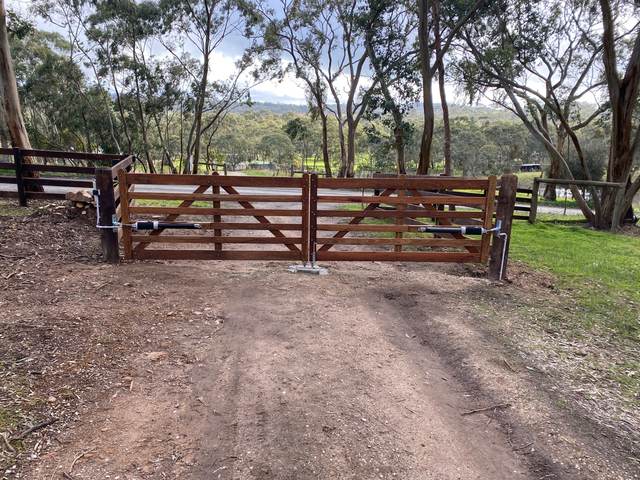 Double timber gates across a rural driveway
