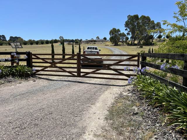Double gates meeting black-painted post and rail