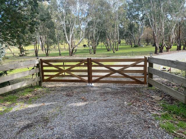 Timber farm gates between post and rail wings