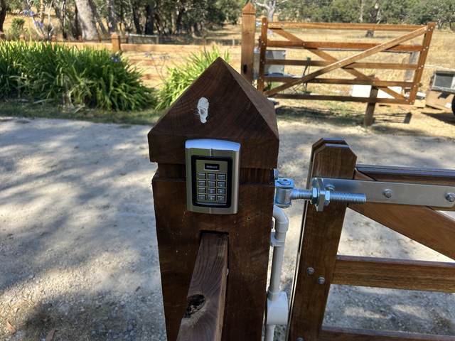 Keypad on a pointed timber post at the gate