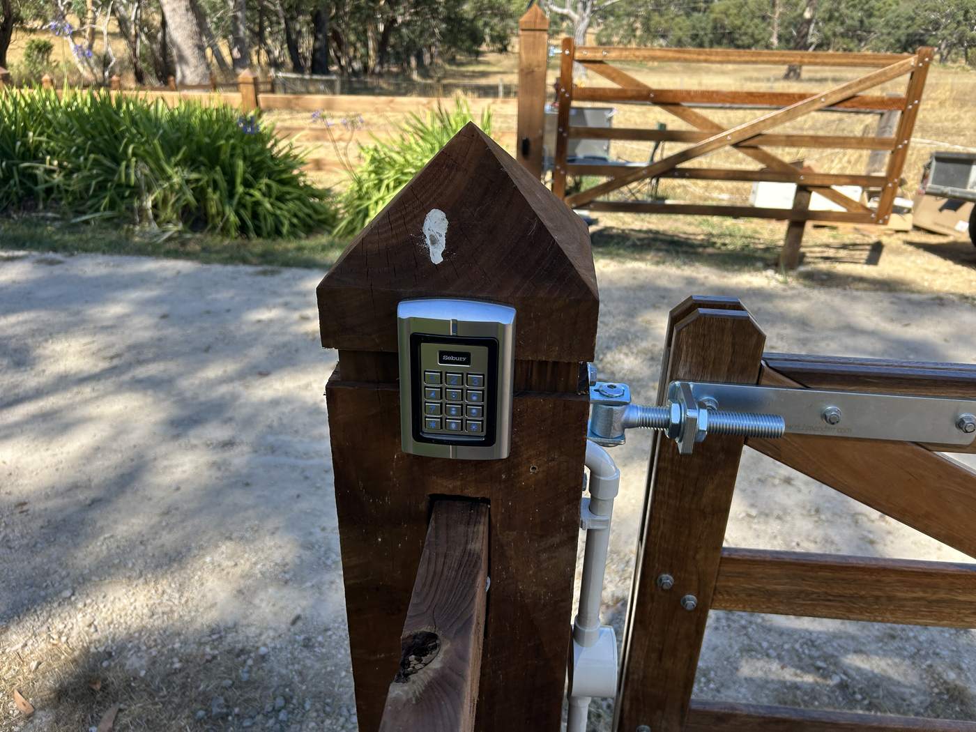Keypad on a pointed timber post at the gate