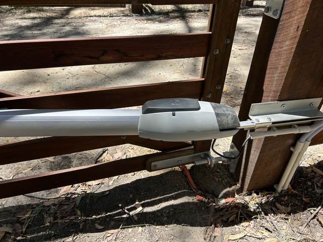 Motor arm mounted on a timber gate post