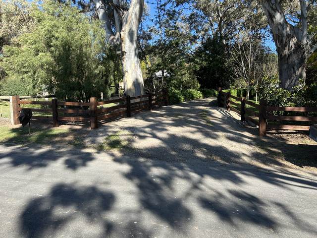 Dark-stained post and rail at a driveway