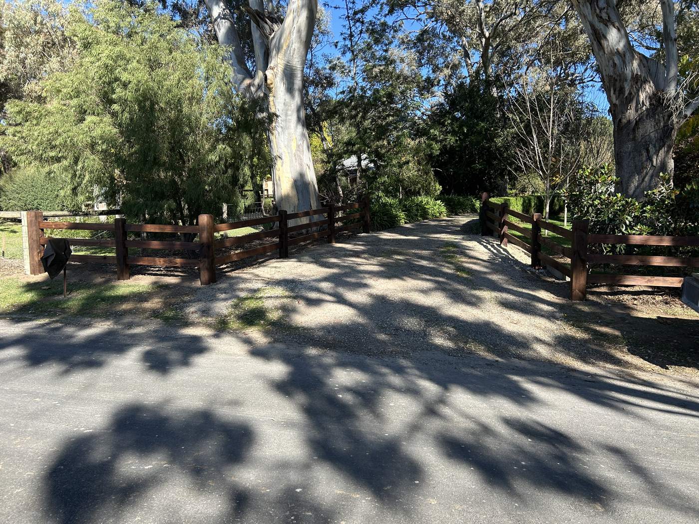 Dark-stained post and rail at a driveway