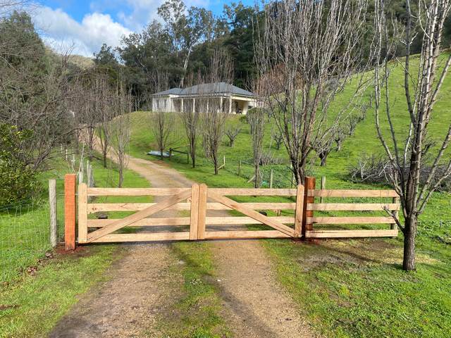 Timber gates and rails across a rural driveway